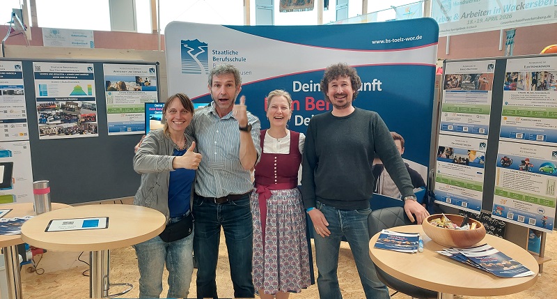 Vier Erwachsene am Messestand